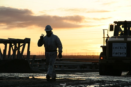 Homme avec couché de soleil derrière lui faisant un Peace sign